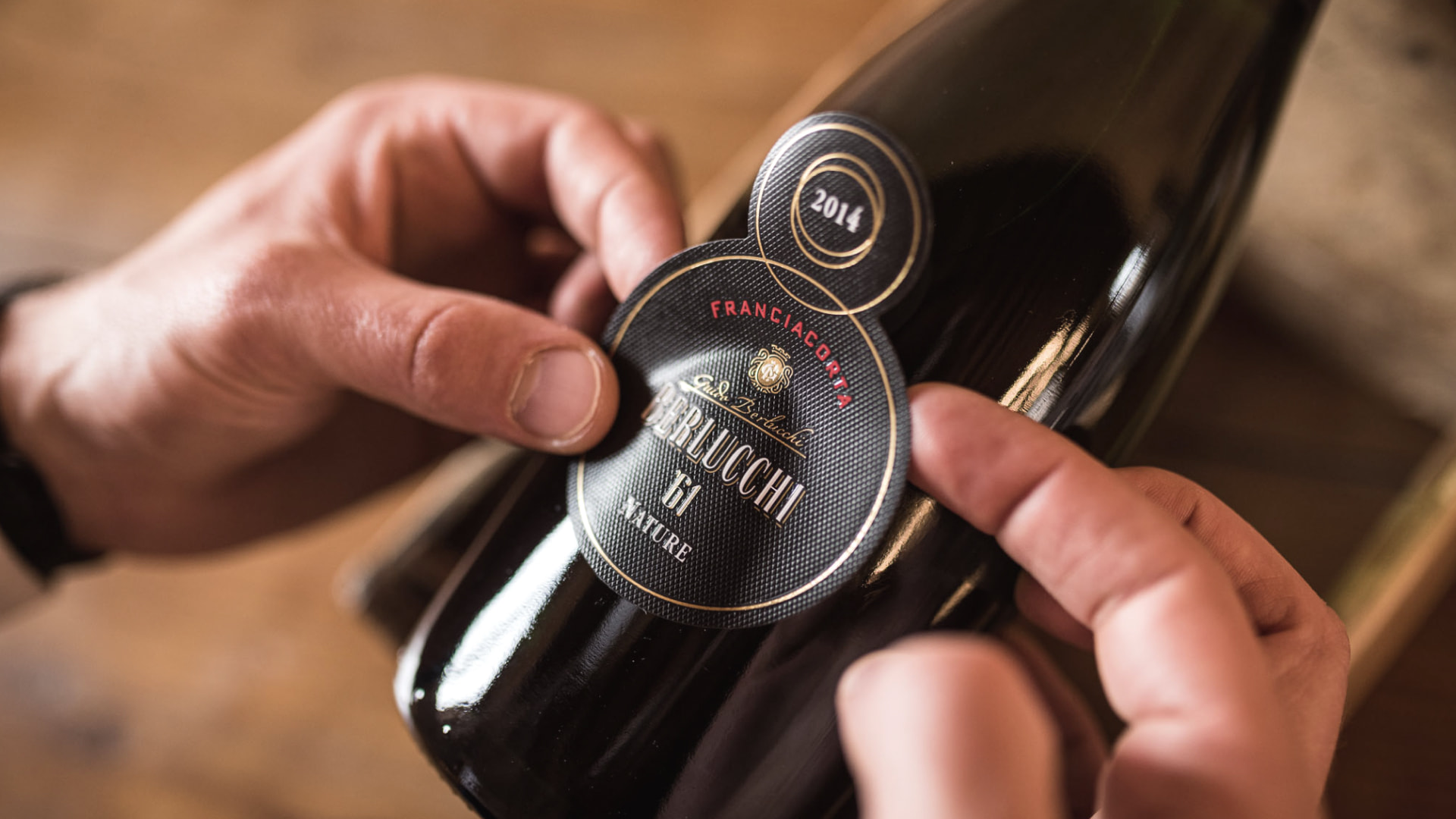 Berlucchi 61 Franciacorta Nature Millesimato DOCG Etikett wird händisch aufgeklebt