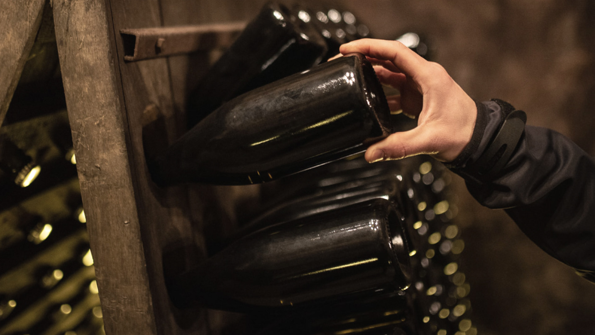 Hand dreht Franciacorta Flasche im Rüttelbrett