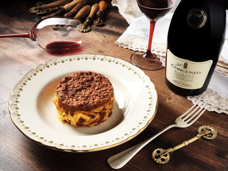 Medici Ermete Concerto Lambruco neben Teller mit Pastagericht